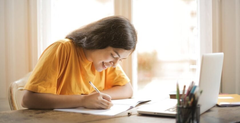 Cover letter for freshers: student writing a letter at a desk