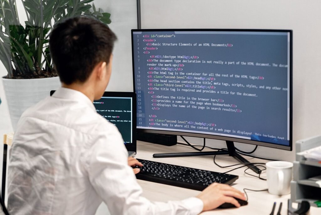 Person writing software code at a computer, representing IT jobs in Pakistan