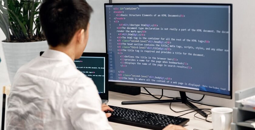 Person writing software code at a computer, representing IT jobs in Pakistan