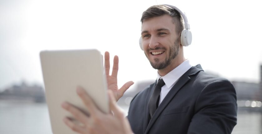 LinkedIn profile for freshers: smiling man waving during an online video call